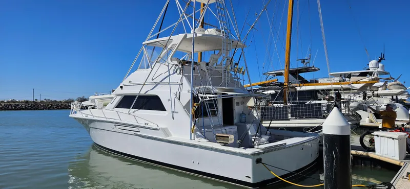 True Grit Yacht Photos Pics 1995 Bertram Convertible yacht docked at marina under clear blue sky.