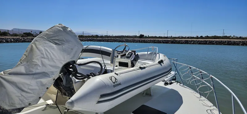True Grit Yacht Photos Pics 1995 Bertram Convertible boat with inflatable dinghy on deck, docked in a calm marina.