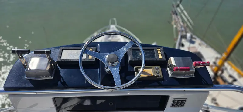 True Grit Yacht Photos Pics 1995 Bertram Convertible yacht helm with steering wheel and controls, overlooking water.