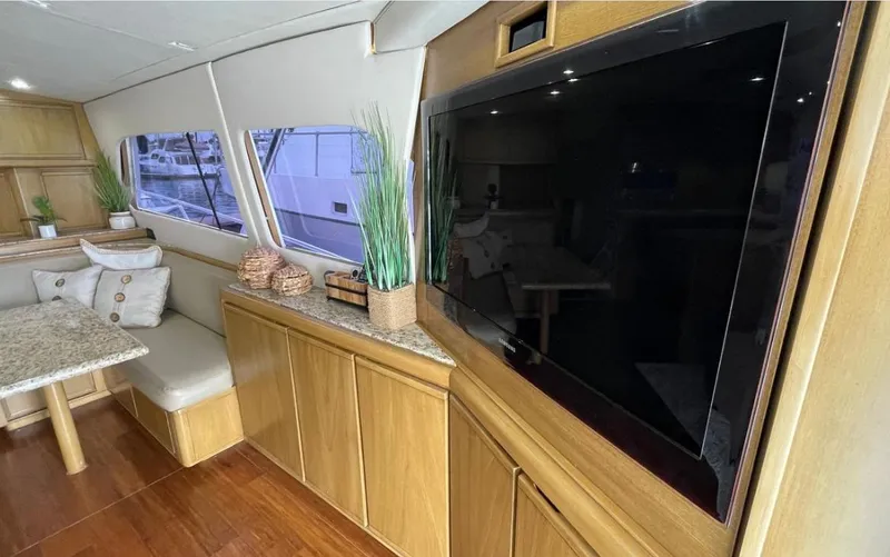 True Grit Yacht Photos Pics Interior of a 1995 Bertram Convertible yacht with modern decor and large TV.