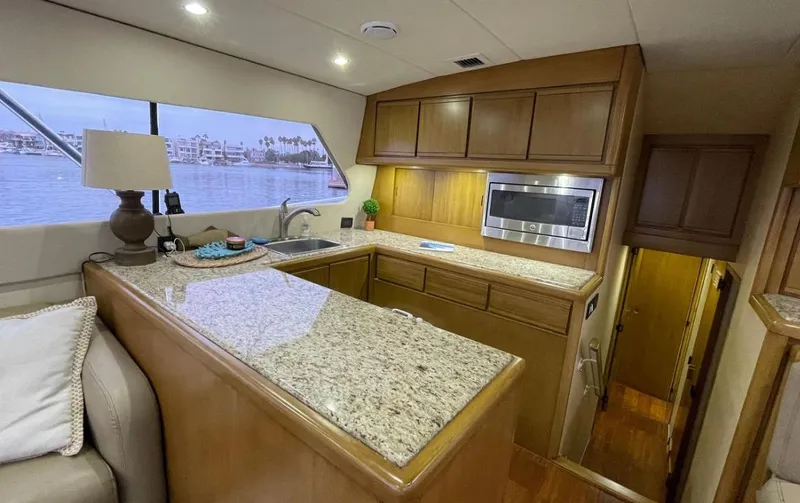 True Grit Yacht Photos Pics Interior of a 1995 Bertram Convertible yacht with a modern kitchen and granite countertops.