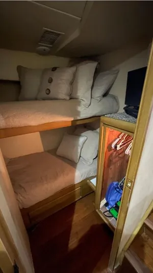 True Grit Yacht Photos Pics Bunk beds in a 1995 Bertram Convertible yacht cabin with pillows and a small closet.