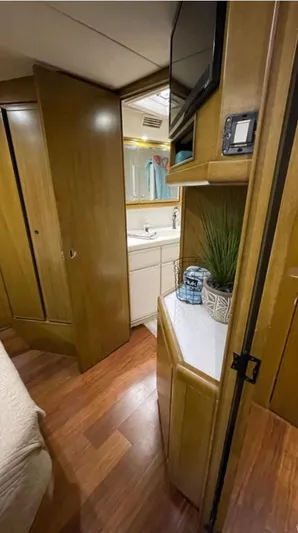 True Grit Yacht Photos Pics Interior of a 1995 Bertram Convertible yacht with wood paneling and compact bathroom.