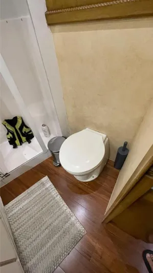 True Grit Yacht Photos Pics Bathroom interior of a 1995 Bertram Convertible yacht with wooden flooring.