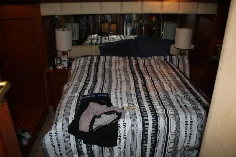 Sweetemocian Yacht Photos Pics 1999 Ocean Yachts bedroom with striped bedding and bedside lamps.
