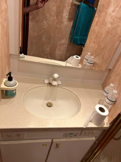 Sweetemocian Yacht Photos Pics Bathroom sink area in a 1999 Ocean Yachts model, featuring toiletries and a mirror.