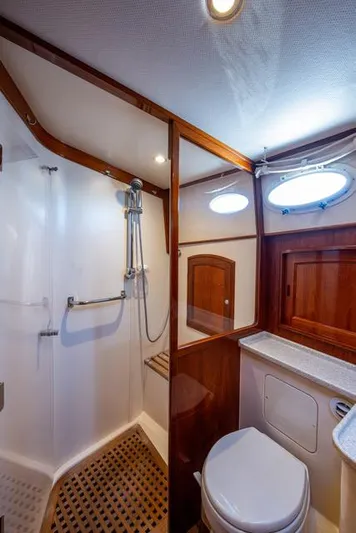 Virginia Yacht Photos Pics 2013 Hinckley Talaria 48 Flybridge bathroom with shower, wooden accents, and porthole windows.