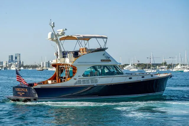 Virginia Yacht Photos Pics 2013 Hinckley Talaria 48 Flybridge yacht cruising in a marina with city skyline.