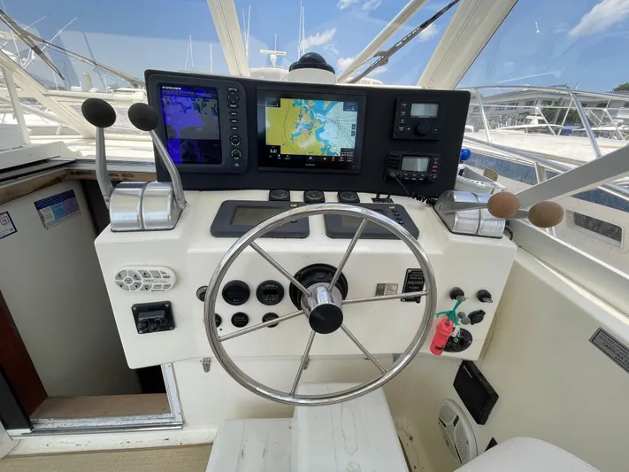  Yacht Photos Pics Helm of 2002 Carolina Classic 35 boat with navigation equipment and steering wheel.