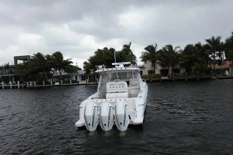 Day Dreams Yacht Photos Pics 2021 Intrepid 409 Valor boat with triple engines on a cloudy day near waterfront homes.