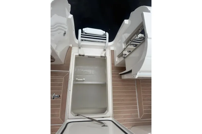 Day Dreams Yacht Photos Pics 2021 Intrepid 409 Valor boat interior with open storage compartment and wooden flooring.