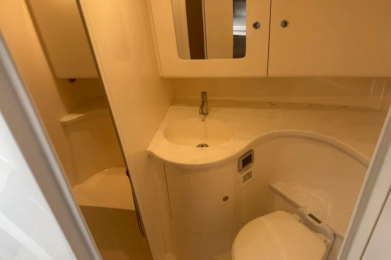 Day Dreams Yacht Photos Pics 2021 Intrepid 409 Valor yacht bathroom with sink, toilet, and storage cabinets.