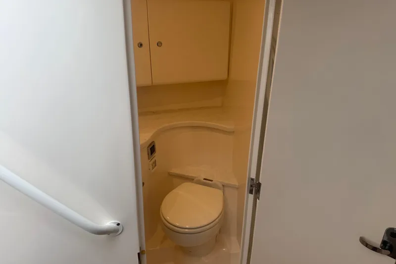 Day Dreams Yacht Photos Pics 2021 Intrepid 409 Valor boat bathroom interior with toilet and storage cabinets.
