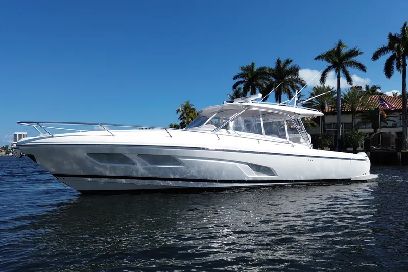 Day Dreams Yacht Photos Pics 2021 Intrepid 409 Valor boat on water, clear sky, palm trees in background.