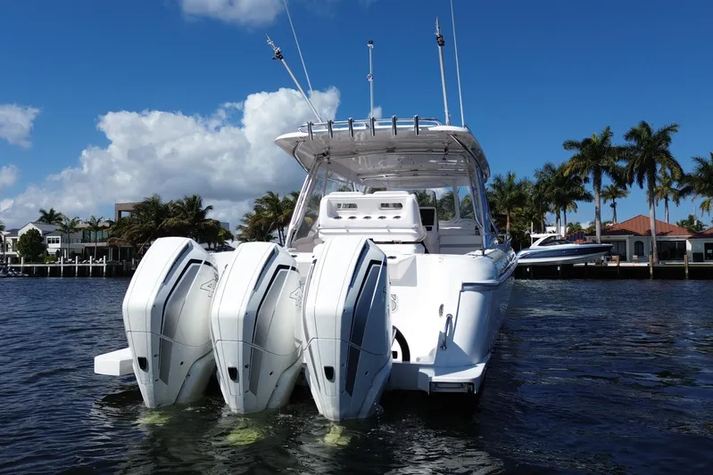 Day Dreams Yacht Photos Pics 2021 Intrepid 409 Valor boat with triple engines on a sunny day, palm trees in background.