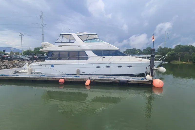 Sea Spirit Yacht Photos Pics 2004 Carver 570 Voyager Pilothouse yacht docked on a calm lake under cloudy skies.
