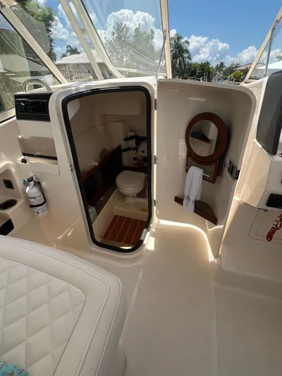 (no Name) Yacht Photos Pics 2019 Grady-White 275 boat interior with bathroom, mirror, and seating.
