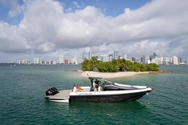  Yacht Photos Pics 2025 Anvera 42 Speedster boat near a small island with city skyline in the background.