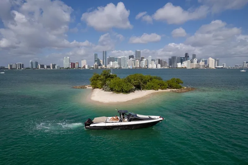  Yacht Photos Pics 2025 Anvera 42 Speedster cruising near a small island with city skyline backdrop.
