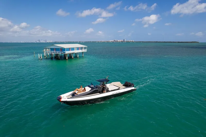  Yacht Photos Pics 2025 Anvera 42 Speedster cruising near a stilt house on turquoise waters.