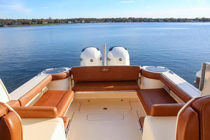Scout 275 Dorado Yacht Photos Pics 2018 Scout 275 Dorado boat with twin engines and spacious seating on a calm lake.