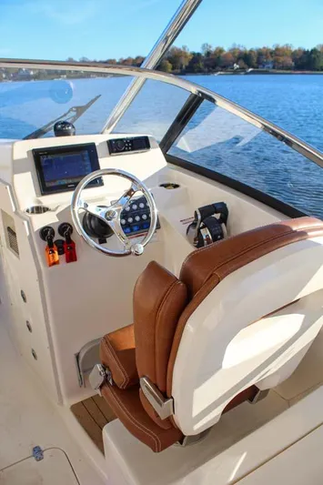 Scout 275 Dorado Yacht Photos Pics 2018 Scout 275 Dorado boat helm with brown leather seat and modern controls.