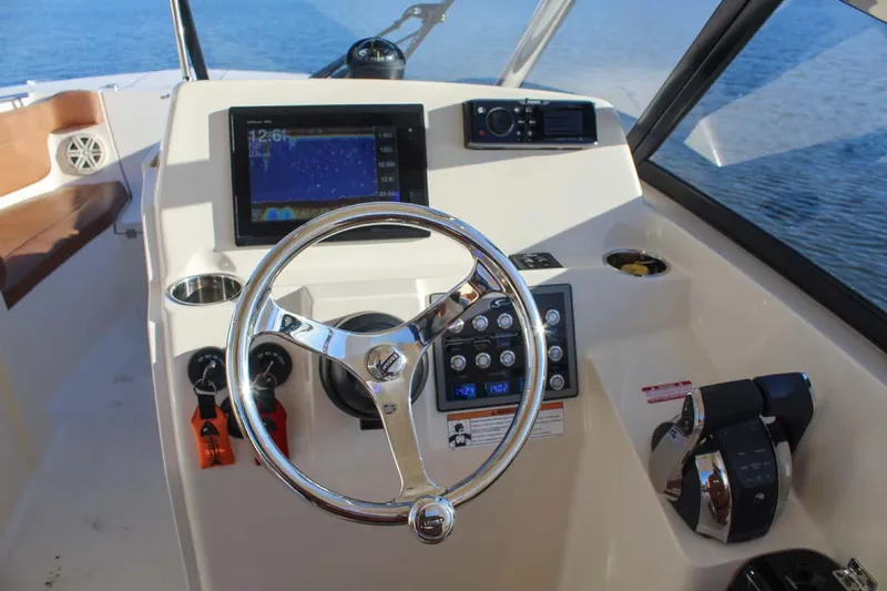Scout 275 Dorado Yacht Photos Pics 2018 Scout 275 Dorado boat dashboard with steering wheel, navigation screen, and controls.