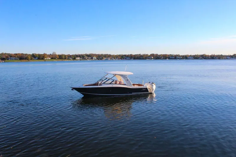 Scout 275 Dorado Yacht Photos Pics 2018 Scout 275 Dorado boat on calm lake with clear blue sky.