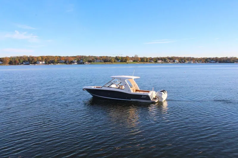Scout 275 Dorado Yacht Photos Pics 2018 Scout 275 Dorado boat on a calm lake with a scenic shoreline.