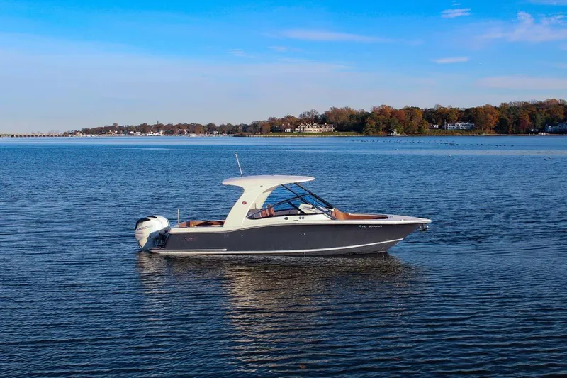 Scout 275 Dorado Yacht Photos Pics 2018 Scout 275 Dorado boat on calm water with scenic shoreline background.
