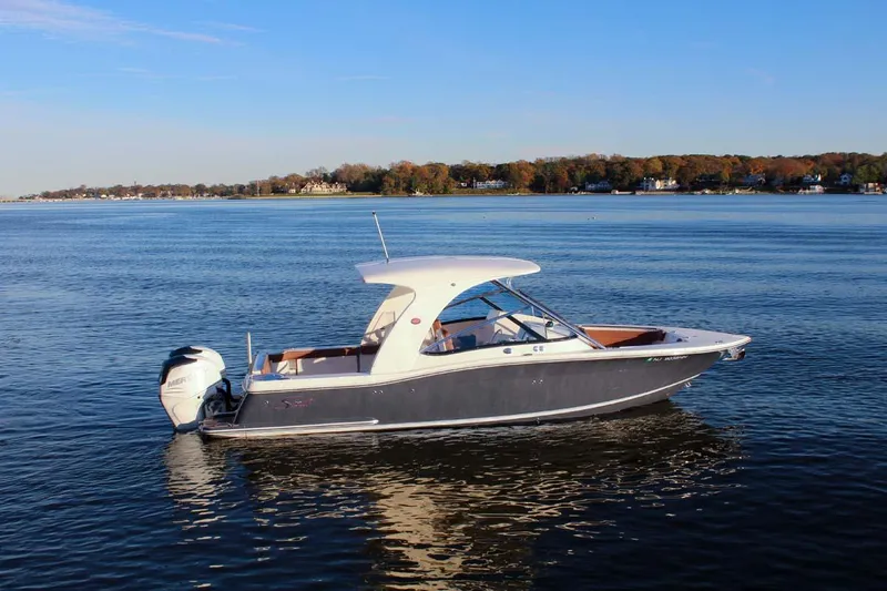 Scout 275 Dorado Yacht Photos Pics 2018 Scout 275 Dorado boat on calm water with scenic shoreline background.