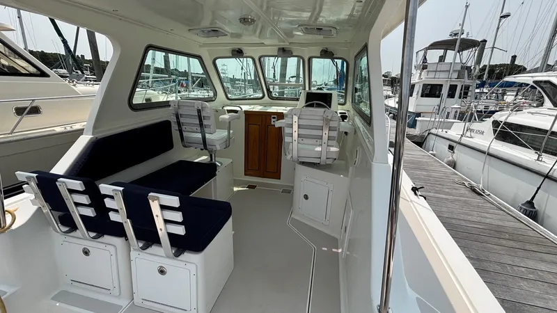 Uncle Ray Yacht Photos Pics 2004 Back Cove 29 boat interior with seating and helm, docked at marina.