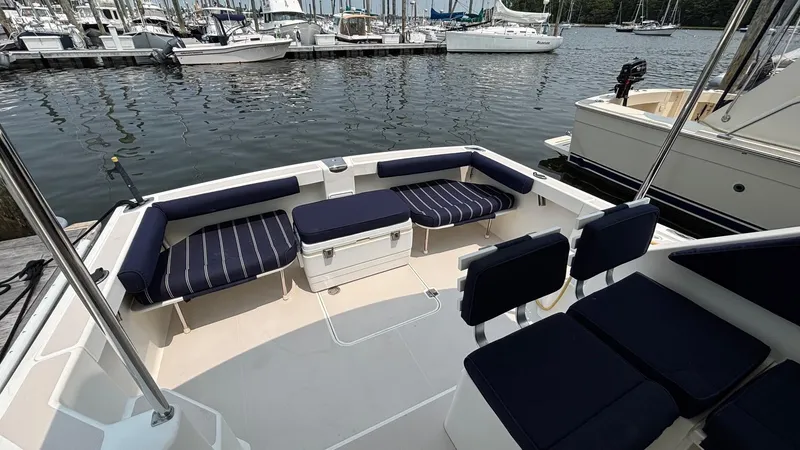 Uncle Ray Yacht Photos Pics 2004 Back Cove 29 boat with cushioned seating, docked at a marina.