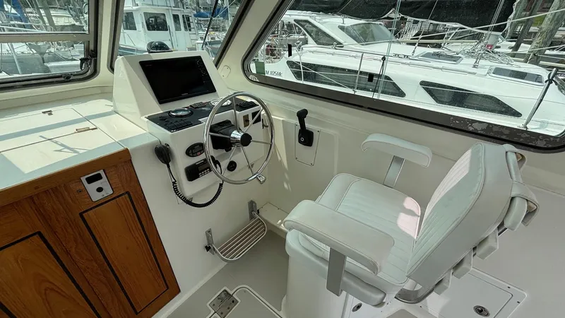Uncle Ray Yacht Photos Pics 2004 Back Cove 29 boat helm with steering wheel, control panel, and captain's chair.