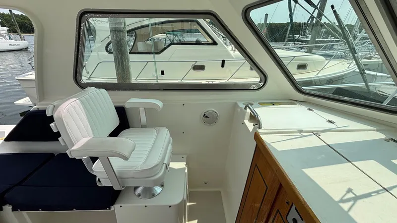 Uncle Ray Yacht Photos Pics Interior view of a 2004 Back Cove 29 boat with white seating and wooden cabinetry.