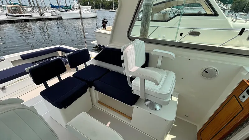 Uncle Ray Yacht Photos Pics 2004 Back Cove 29 boat interior with white and navy seating, docked at marina.