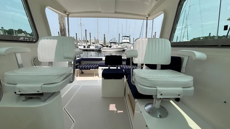 Uncle Ray Yacht Photos Pics Interior of 2004 Back Cove 29 boat with white seating and marina view.