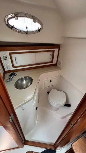 Uncle Ray Yacht Photos Pics 2004 Back Cove 29 boat bathroom with sink, toilet, and storage cabinets.