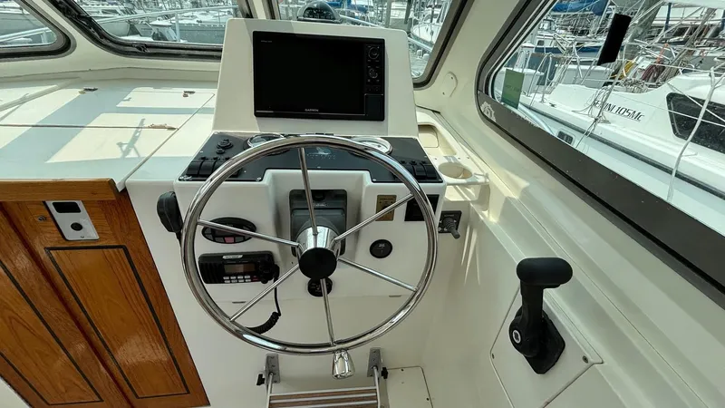 Uncle Ray Yacht Photos Pics Helm of 2004 Back Cove 29 boat with steering wheel and navigation equipment.