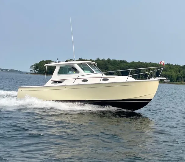 Uncle Ray Yacht Photos Pics 2004 Back Cove 29 boat cruising on a calm lake with forested shoreline.