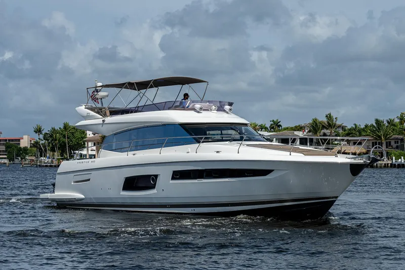 Lifesaver Yacht Photos Pics 2014 Prestige 550 yacht cruising on a calm waterway under a cloudy sky.