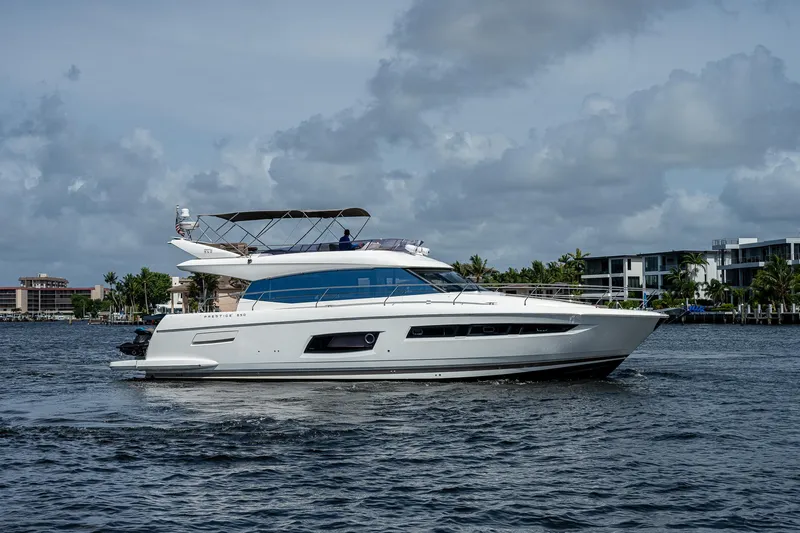 Lifesaver Yacht Photos Pics Luxury 2014 Prestige 550 yacht cruising on a calm waterway under a cloudy sky.