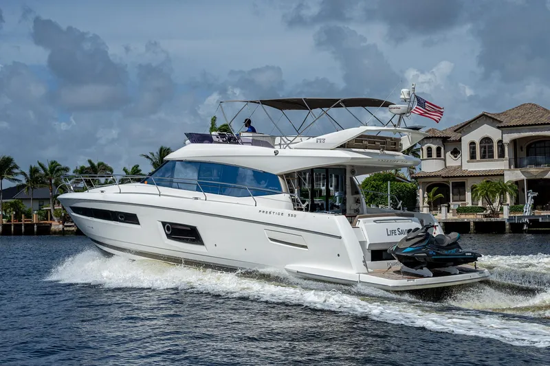 Lifesaver Yacht Photos Pics 2014 Prestige 550 yacht cruising on water near luxury waterfront homes.