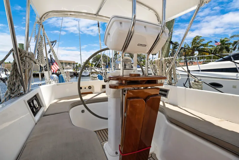 Southern Cross Yacht Photos Pics Cockpit of 2004 Hylas 46 sailboat with steering wheel and seating, docked at marina.