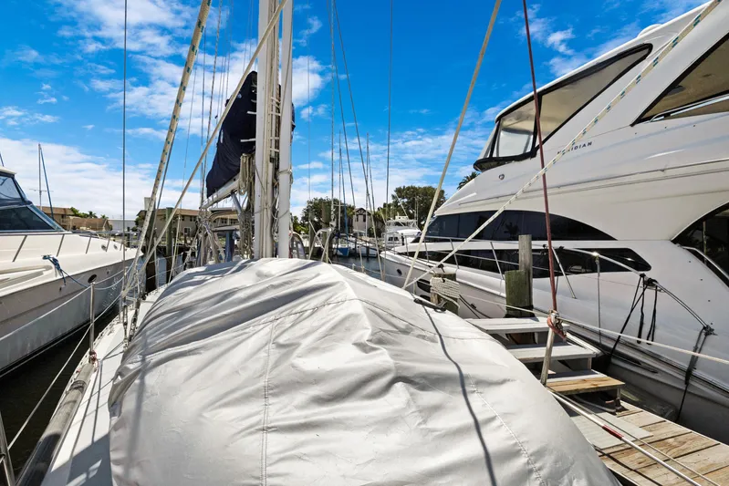 Southern Cross Yacht Photos Pics Sailboat docked at marina, Hylas 46, 2004 model, surrounded by yachts under blue sky.
