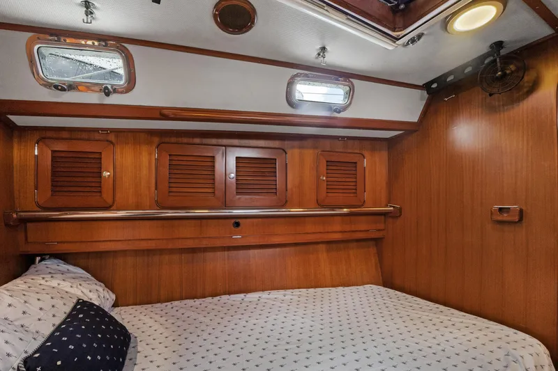 Southern Cross Yacht Photos Pics Cozy cabin interior of 2004 Hylas 46 yacht with wooden paneling and portholes.