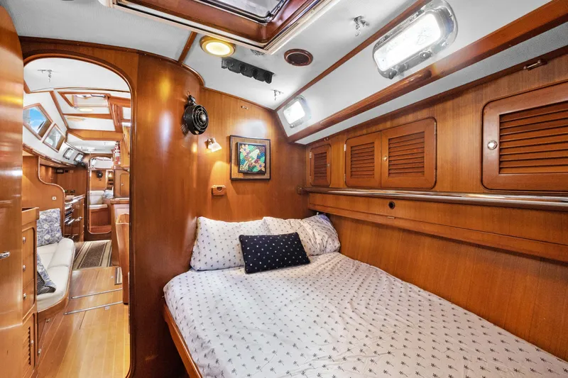 Southern Cross Yacht Photos Pics Cozy cabin interior of 2004 Hylas 46 yacht with wooden finish and comfortable bedding.