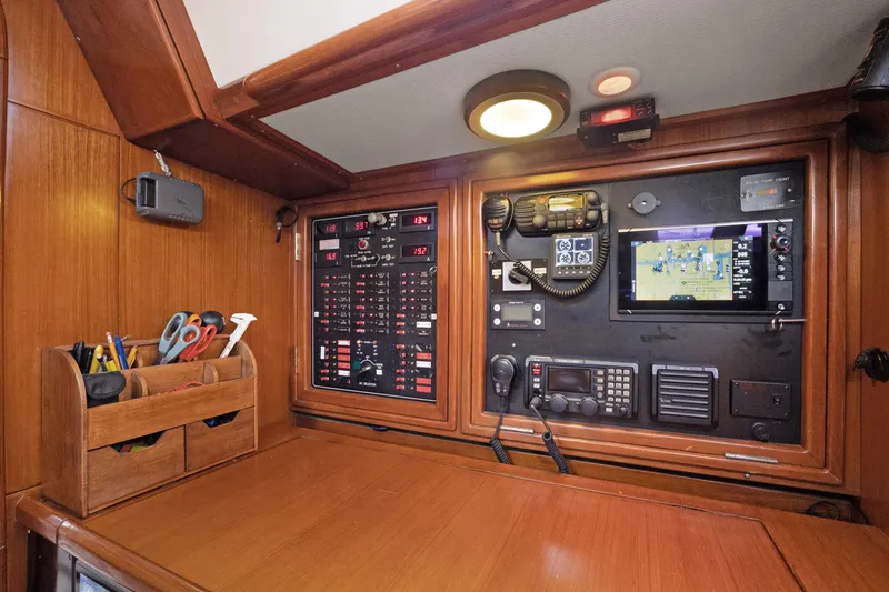 Southern Cross Yacht Photos Pics Navigation station of a 2004 Hylas 46 yacht with control panels and tools.