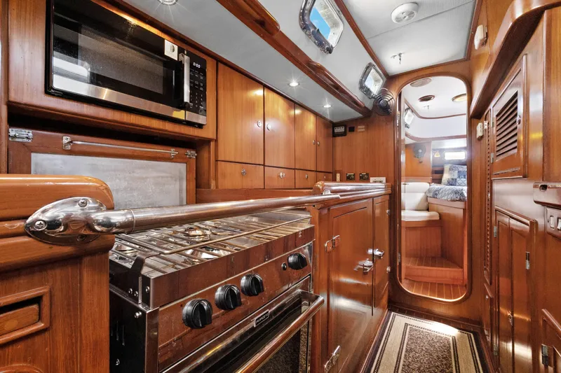 Southern Cross Yacht Photos Pics Luxurious 2004 Hylas 46 yacht interior with wood finish and modern kitchen amenities.