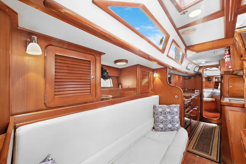 Southern Cross Yacht Photos Pics Luxurious 2004 Hylas 46 yacht interior with wooden finish and white seating.